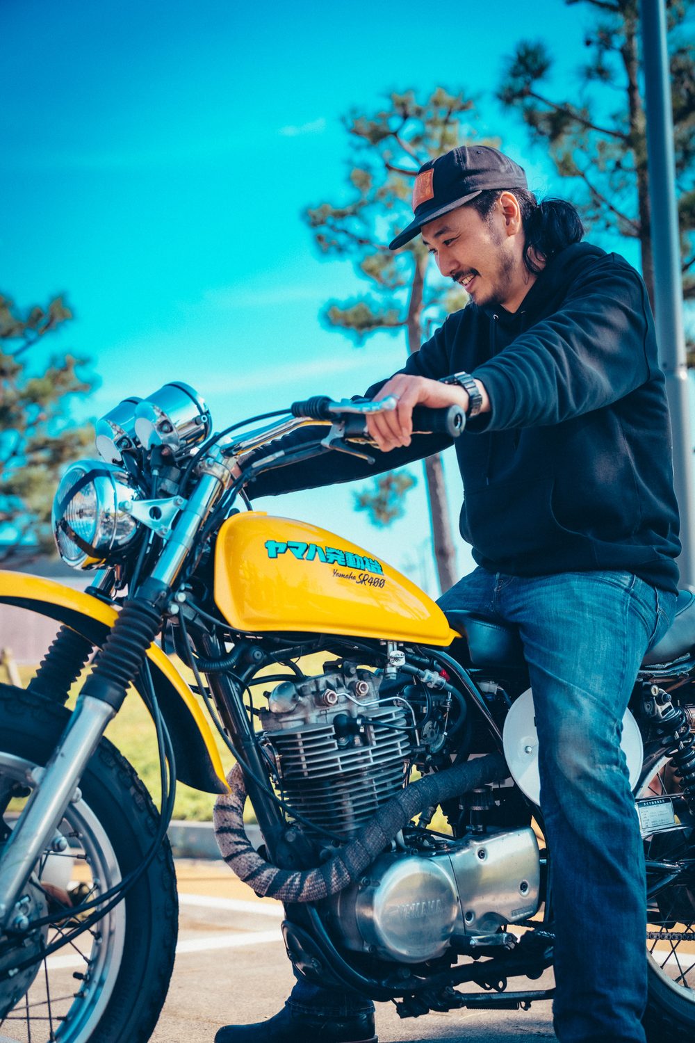 完成した黄色いSR400スクランブラーに跨るGOODSの堀さん